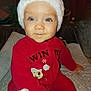 baby, blanket, blue_eyes, child, cozy, cute, face, festive, hand, holiday, indoor, infant, noel, portrait, red_onesie, seated, smile, soft_lighting, warm_clothing, winter_hat