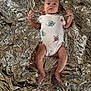 Danté joined the competition — help win amazing prizes! baby, infant, onesie, cartoon_print, lying_down, metallic_surface, space_blanket, crinkled, skin, barefoot, small_hands, cute, child, young, portrait, indoors, soft_light, expressionless, head, feet