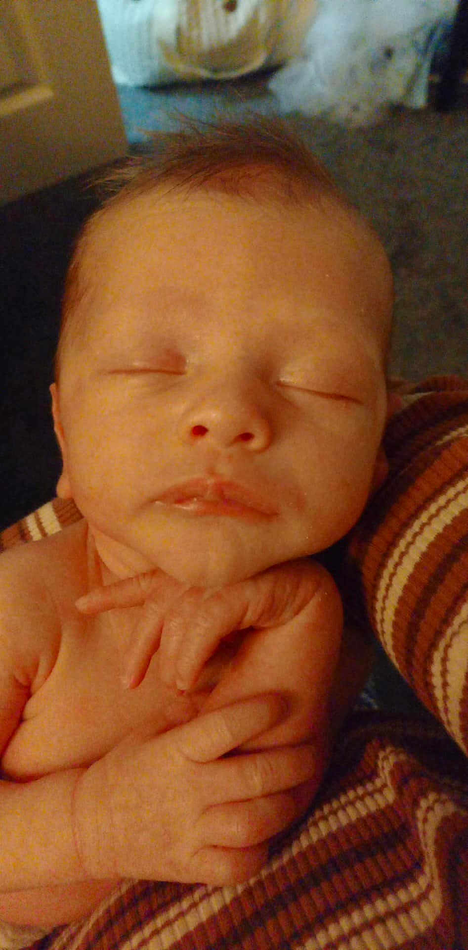 Danté is registered to the contest to win money with this photo: newborn, baby, sleeping, hands, face, skin, blanket, striped, cozy, peaceful, infant, closeup, resting, cute, child, portrait, indoors, soft, tiny, calm