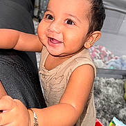 Luca is registered to the contest to win money with this photo: baby, child, smile, happy, face, arm, bracelet, indoor, toy, carpet, clothing, person, cute, closeup, infant, playful, furniture, soft, expression, warm