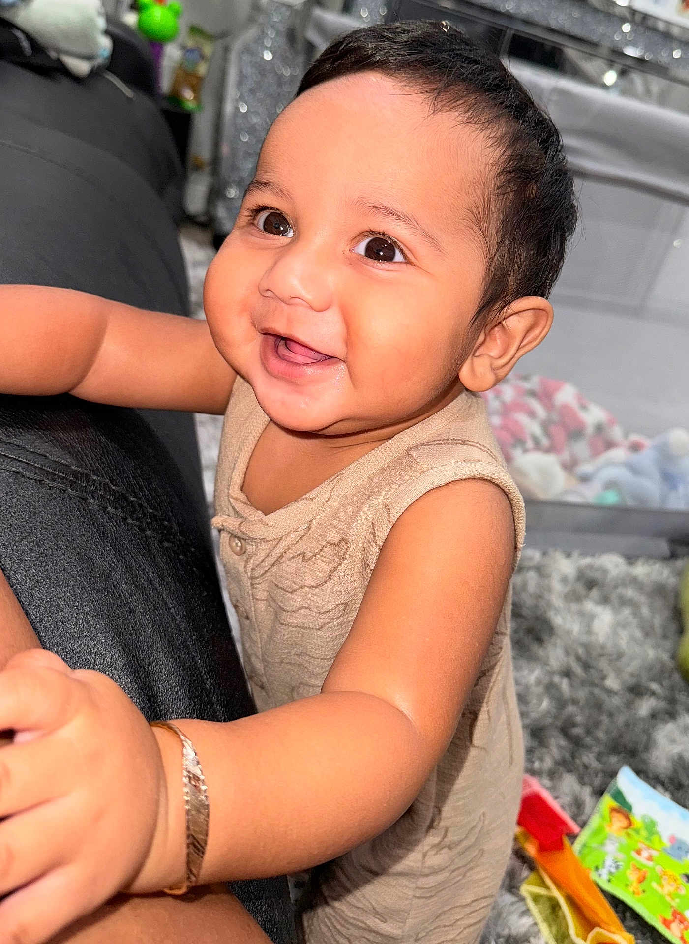 Luca is registered to the contest to win money with this photo: baby, child, smile, happy, face, arm, bracelet, indoor, toy, carpet, clothing, person, cute, closeup, infant, playful, furniture, soft, expression, warm