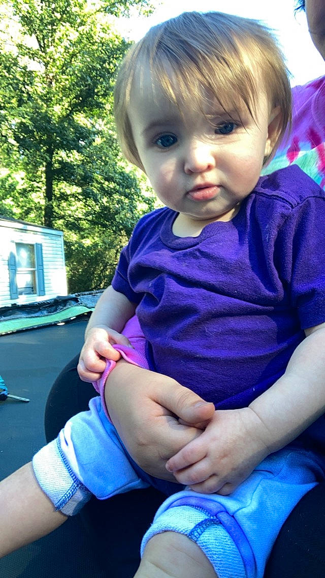 Paisley is registered to the contest to win money with this photo: arm, baby, baby_toddler_clothing, blue, cool, facial_expression, finger, fun, grass, hairstyle, hand, happy, human_body, joint, mammal, person, plant, shoulder, t_shirt, toddler