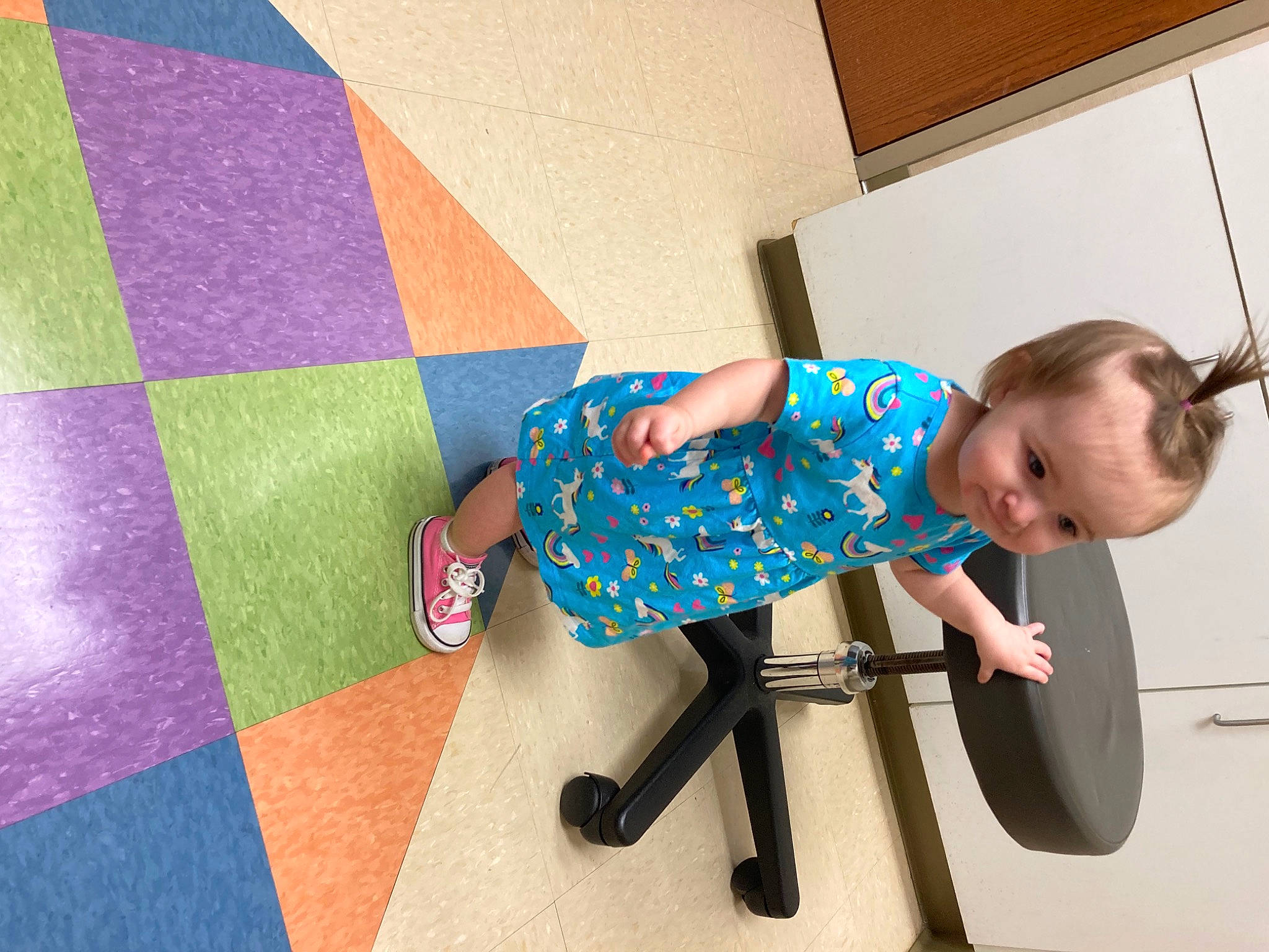 Paisley is registered to the contest to win money with this photo: baby, baby_toddler_clothing, chair, child, electric_blue, floor, flooring, fun, human_leg, knee, leg, pattern, person, room, sandal, sitting, sneakers, sock, t_shirt, thigh