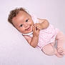 baby, smiling, curly_hair, pink_dress, tights, infant, cute, lying_down, joyful, pastel_background, child, happy, portrait, soft_texture, small_hands, innocent, playful, cheerful, closeup, adorable