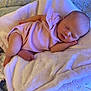 baby, sleeping, pink_outfit, blanket, cushion, infant, newborn, soft_texture, cozy, peaceful, indoor, resting, child, cute, small, human, portrait, bedroom, comfort, relaxation