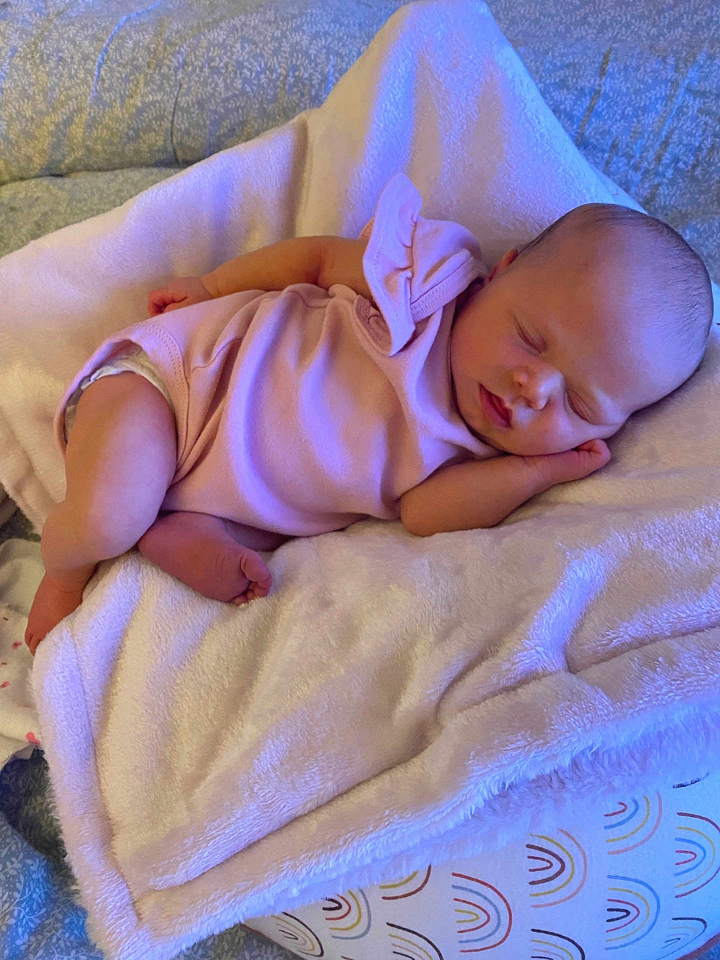 Nevaeh is registered to the contest to win money with this photo: baby, sleeping, pink_outfit, blanket, cushion, infant, newborn, soft_texture, cozy, peaceful, indoor, resting, child, cute, small, human, portrait, bedroom, comfort, relaxation