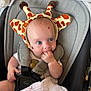 Lottie is registered to the contest to win money with this photo: baby, giraffe_hat, car_seat, blanket, infant, child, cute, blue_eyes, hand, clothing, seatbelt, soft_toy, indoor, portrait, headwear, sitting, comfort, expression, baby_accessory, infant_care
