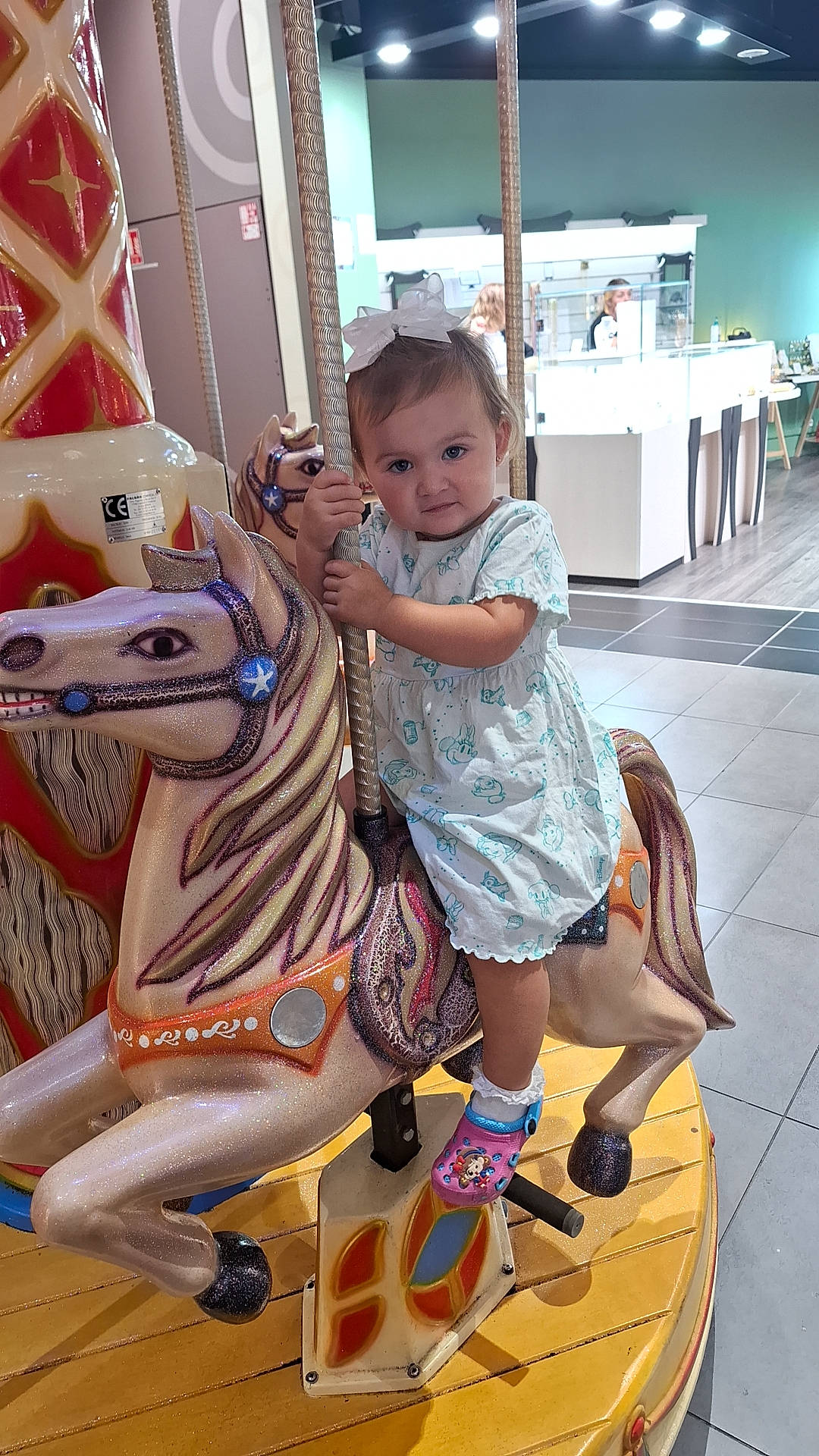 Emma participe au concours pour gagner de l'argent avec cette photo : beauty, carousel, child, event, fashion, fashion_design, flooring, fun, hairstyle, happy, horse, human_leg, leisure, person, product, recreation, room, sandal, standing, toddler