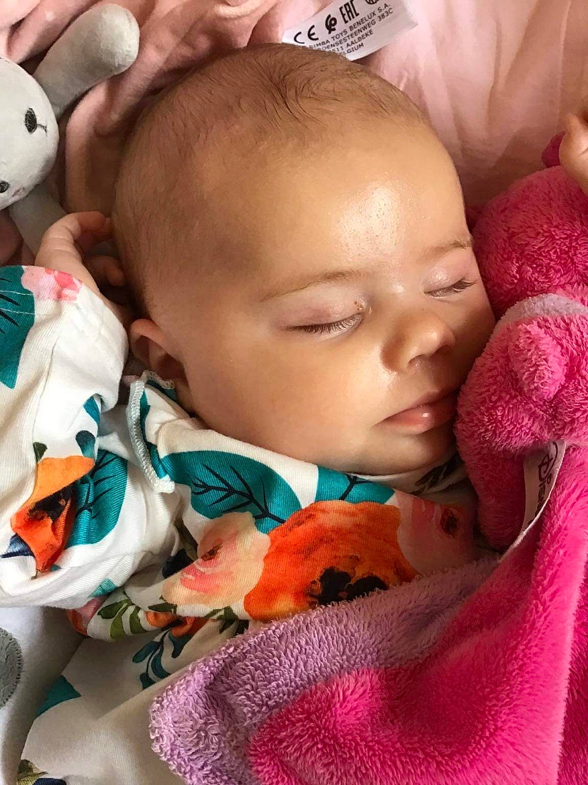 Elena participe au concours pour gagner de l'argent avec cette photo : baby, baby_toddler_clothing, cheek, child, comfort, eyelash, facial_expression, happy, linens, mammal, mouth, nose, organ, person, pink, product, room, skin, textile, toddler