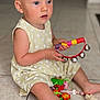 toddler, child, blonde_hair, blue_eyes, yellow_dress, sitting, floor, tiles, tambourine, toy, colorful, indoor, pacifier, foot, play, curious, young_child, person, baby, cute