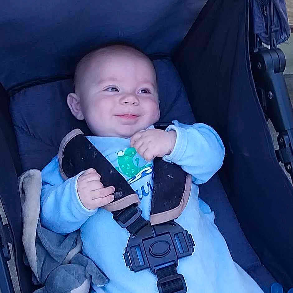 Ayden a rejoint le concours — aidez-le/la à gagner de superbes lots ! baby, baby_accessory, baby_clothing, baby_expression, baby_face, baby_gesture, baby_hands, baby_seat, baby_transport, blue_onesie, cheeky, child, cute, happy, infant, outdoor, plush_toy, seatbelt, smile, stroller