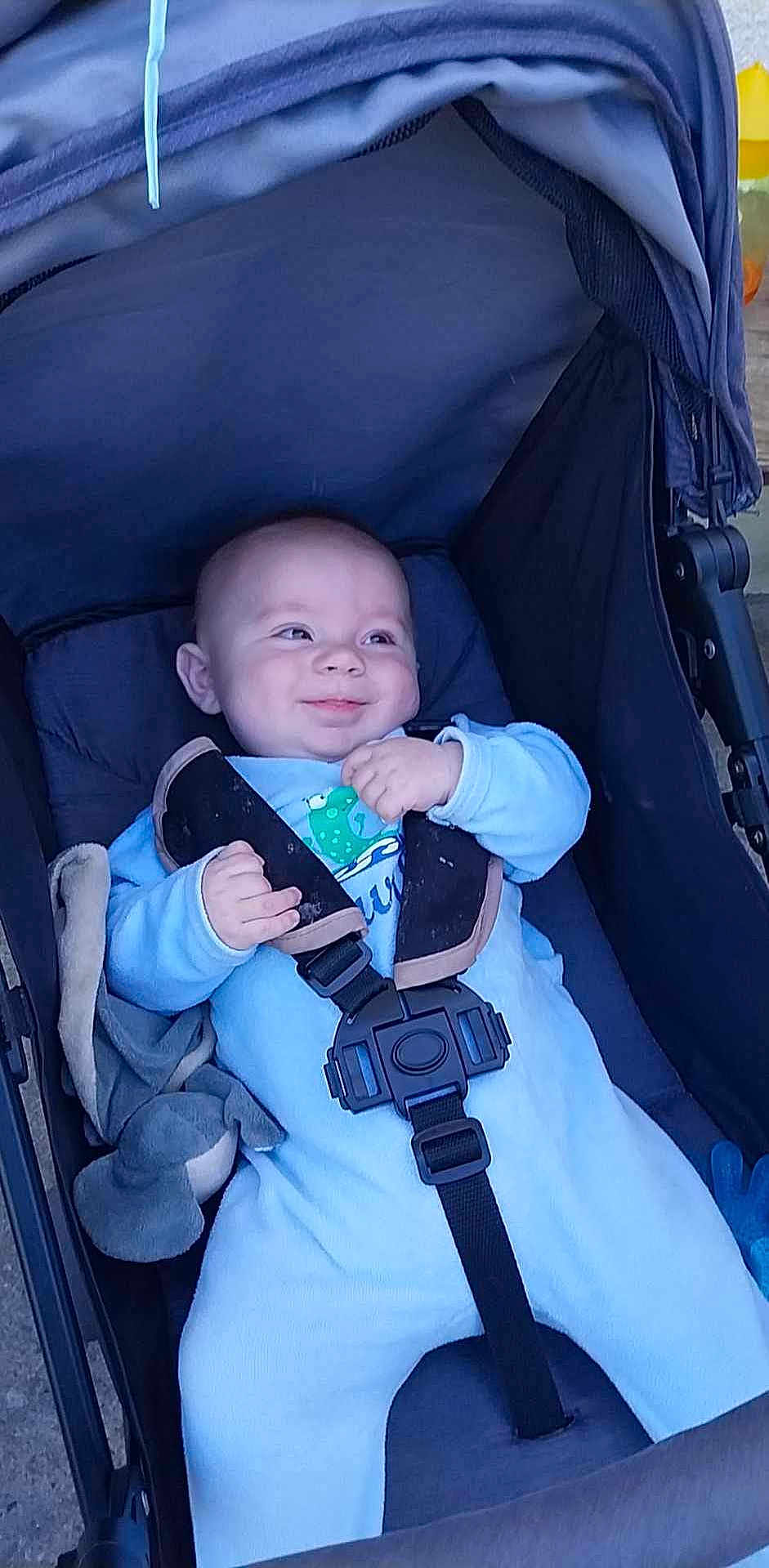 Ayden a rejoint le concours — aidez-le/la à gagner de superbes lots ! baby, stroller, blue_onesie, smile, child, infant, plush_toy, seatbelt, outdoor, happy, cute, cheeky, baby_face, baby_hands, baby_clothing, baby_accessory, baby_seat, baby_transport, baby_gesture, baby_expression