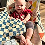 Cole is registered to the contest to win money with this photo: baby, infant, child, smile, bouncer_seat, patterned_fabric, blanket, checkered_blanket, red_onesie, feet, hands, leg, face, head, indoor, wooden_floor, portrait, geometric_pattern, cozy, happy