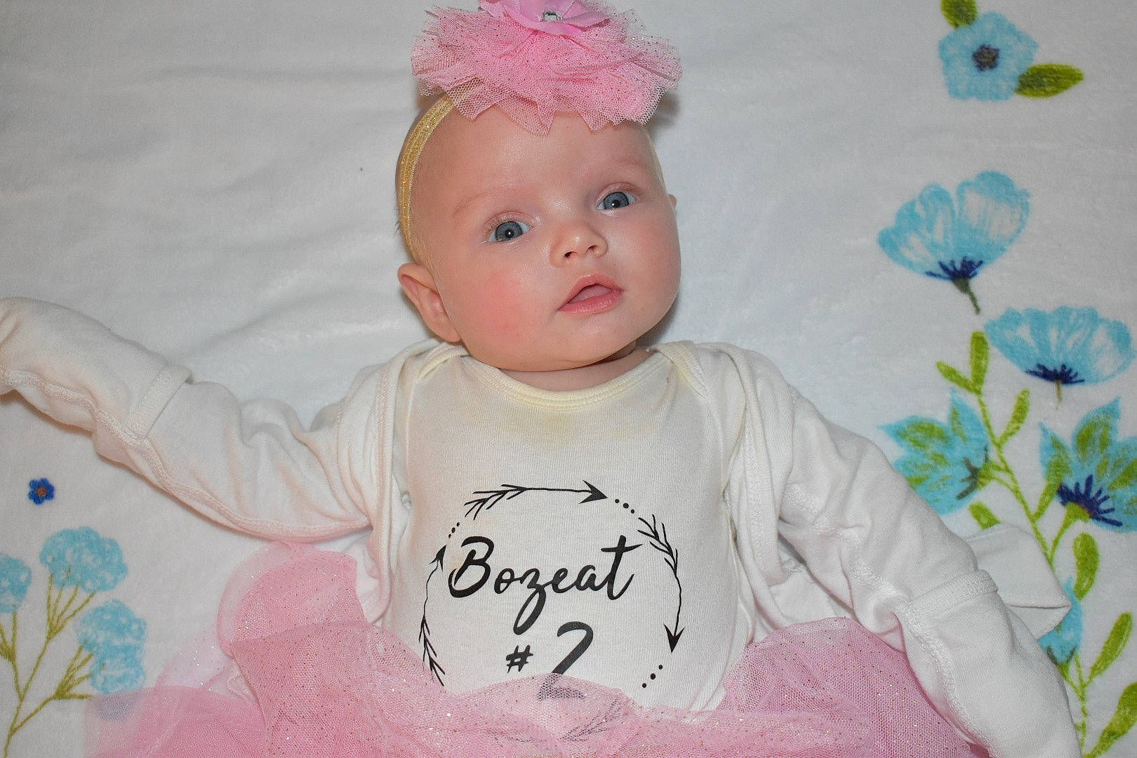 River is registered to the contest to win money with this photo: baby, baby_products, baby_toddler_clothing, cap, cheek, child, costume_hat, face, fashion_accessory, happy, head, headpiece, headwear, magenta, pattern, person, pink, sleeve, t_shirt, textile