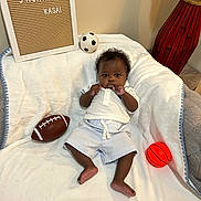 Kasai joined the competition — help win amazing prizes! baby, basketball, blanket, celebration, child, cute, decor, football, happy, home, indoor, infant, letter_board, lying_down, milestone, portrait, smiling, soccer_ball, sports_ball, white_clothing