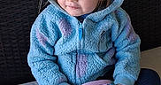 Robin joined the competition — help win amazing prizes! blue, casual_clothing, child, cozy, curly_hair, cute, footwear, hoodie, indoor, person, playful, pop_it_toy, portrait, purple, relaxed, sitting, smiling, toddler, toy, young_child