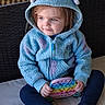 Robin joined the competition — help win amazing prizes! toddler, child, hoodie, blue, purple, pop_it_toy, toy, sitting, casual_clothing, footwear, indoor, curly_hair, cute, playful, young_child, person, portrait, cozy, relaxed, smiling