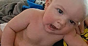 Parker is registered to the contest to win money with this photo: arm, baby, blanket, child, clothing, coat, cuddly, curious, door, expression, face, furniture, head, home, human, indoor, infant, leaning, person, skin