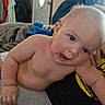 Parker is registered to the contest to win money with this photo: baby, child, infant, face, skin, arm, blanket, indoor, person, home, door, clothing, coat, furniture, curious, leaning, expression, head, human, cuddly