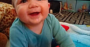 Parker joined the competition — help win amazing prizes! baby, child, smiling, plush_toy, blue_clothing, indoor, playroom, colorful, blanket, toy, happy, face, person, crawling, cute, infant, warm, soft, floor, young