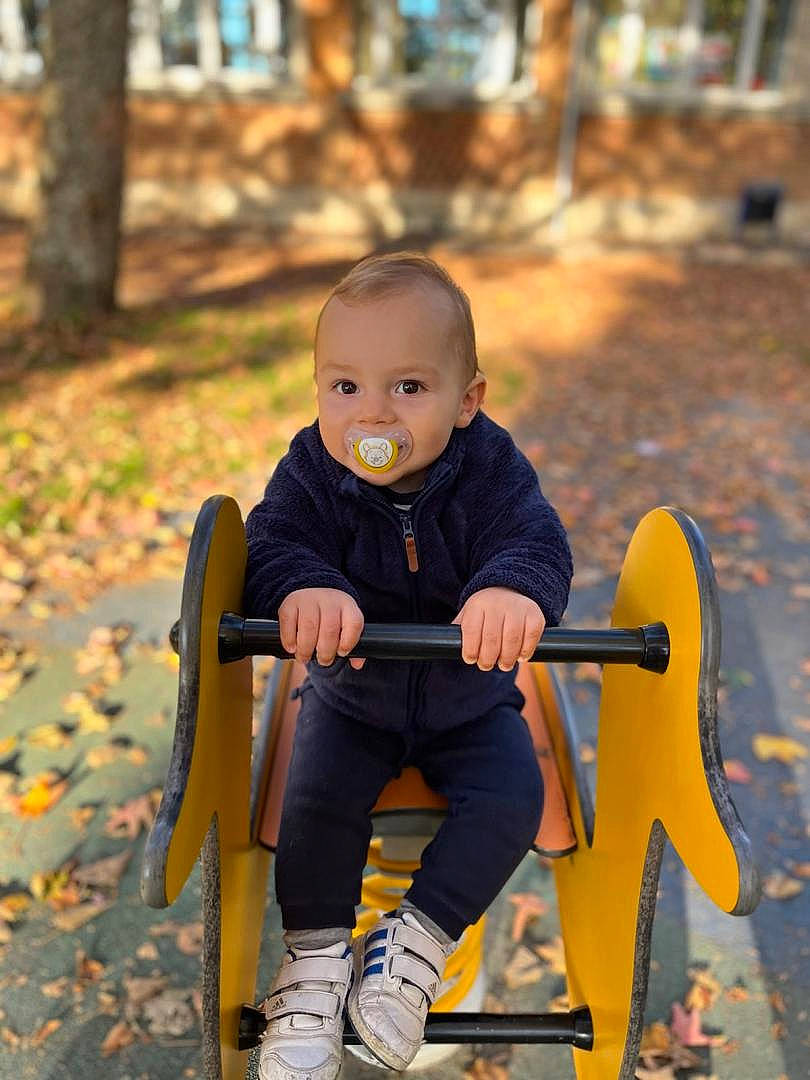 Sacha participe au concours pour gagner de l'argent avec cette photo : baby, baby_carriage, baby_products, chair, child, city, electric_blue, fun, grass, happy, leisure, outdoor_play_equipment, people_in_nature, person, recreation, sitting, smile, sunlight, toddler, tree