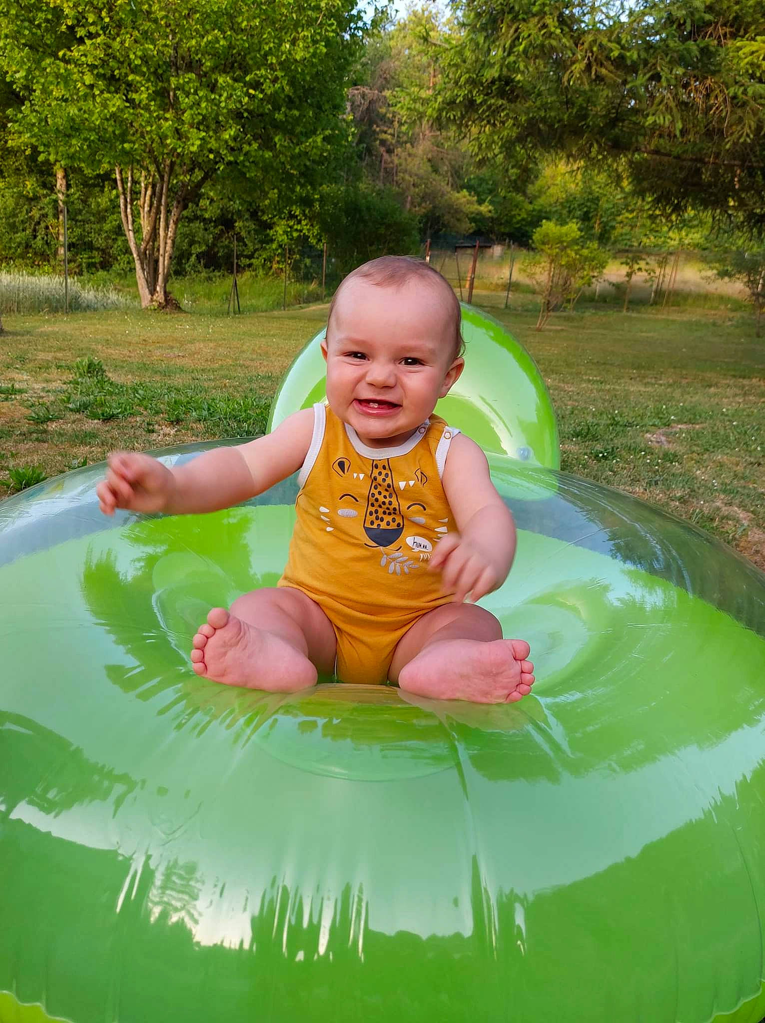 Sacha a rejoint le concours — aidez-le/la à gagner de superbes lots ! baby, baby_toddler_clothing, bathing, child, fun, grass, green, happy, inflatable, joy, leisure, person, plant, play, recreation, sitting, smile, summer, toddler, tree