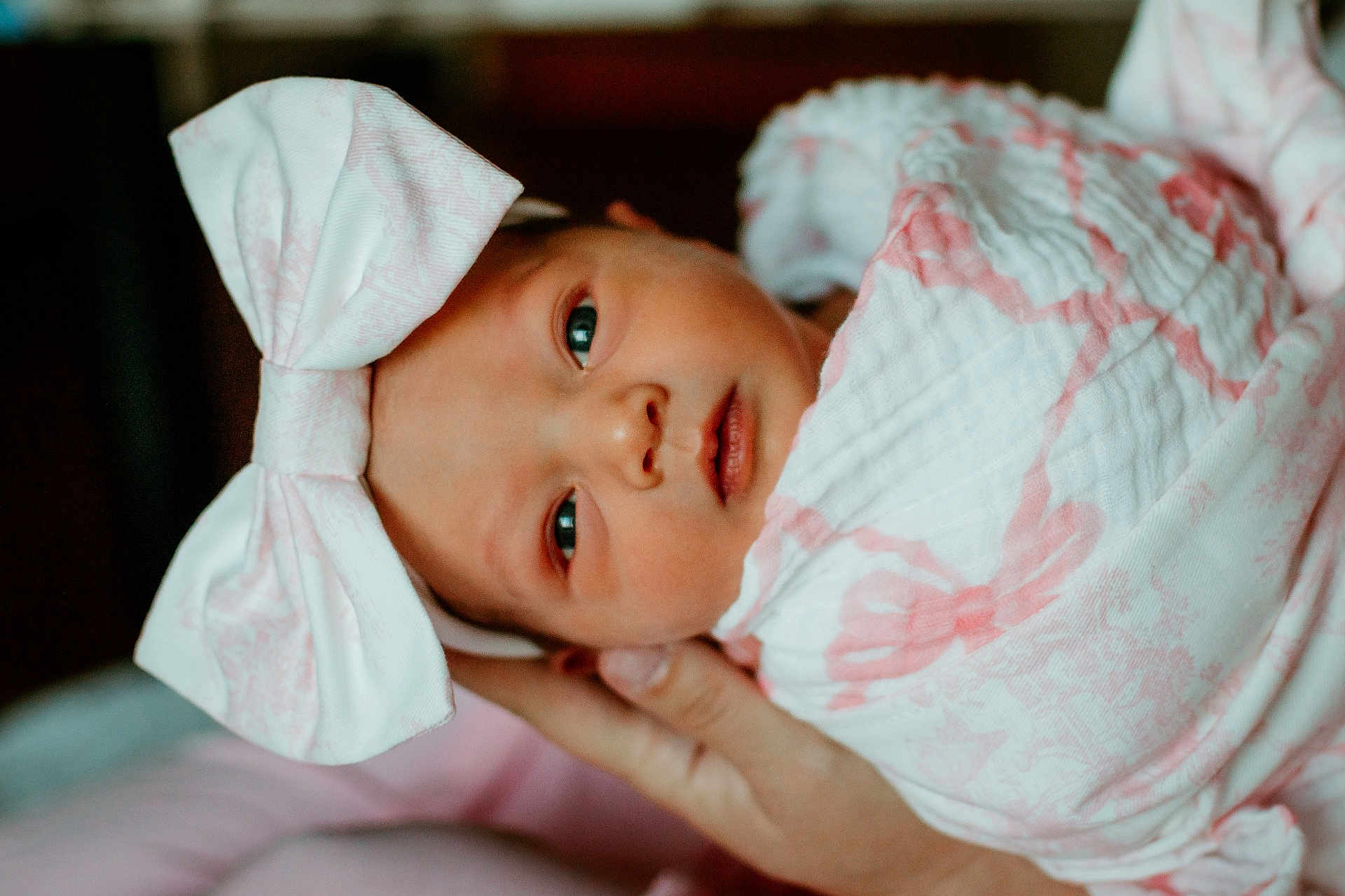 Sara is registered to the contest to win money with this photo: baby, infant, newborn, wrapped, blanket, headband, bow, pink, white, face, eyes, hand, soft, cute, portrait, indoors, person, newborn_baby, gentle, sleepy