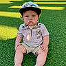 Kollins is registered to the contest to win money with this photo: barefoot, blue_eyes, building, cap, casual_clothing, child, cute, daytime, dog_patch, expression, grass, outdoor, park, people, shadow, shorts, sitting, striped_shirt, sunlight, toddler