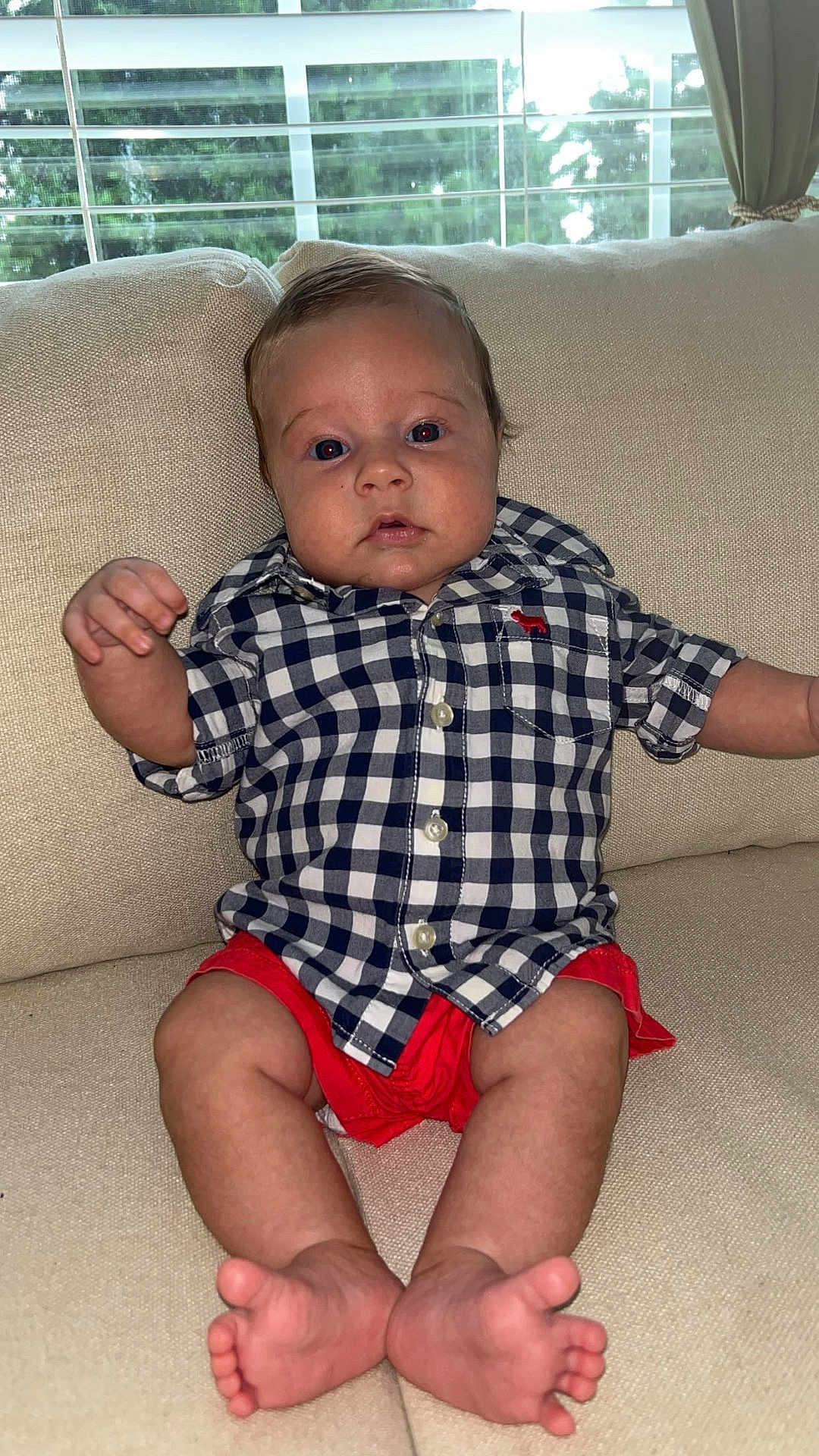 Kollins is registered to the contest to win money with this photo: baby, infant, child, couch, indoor, clothing, shirt, shorts, barefoot, feet, face, window, curtain, home, furniture, seated, skin, expression, portrait, young