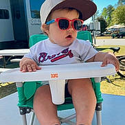 Kollins joined the competition — help win amazing prizes! baby, baseball_cap, bicycle, child, daytime, footwear, grass, green_chair, high_chair, outdoor, person, recreational_vehicle, shade, shorts, summer, sunglasses, sunny, table, toddler, white_tshirt