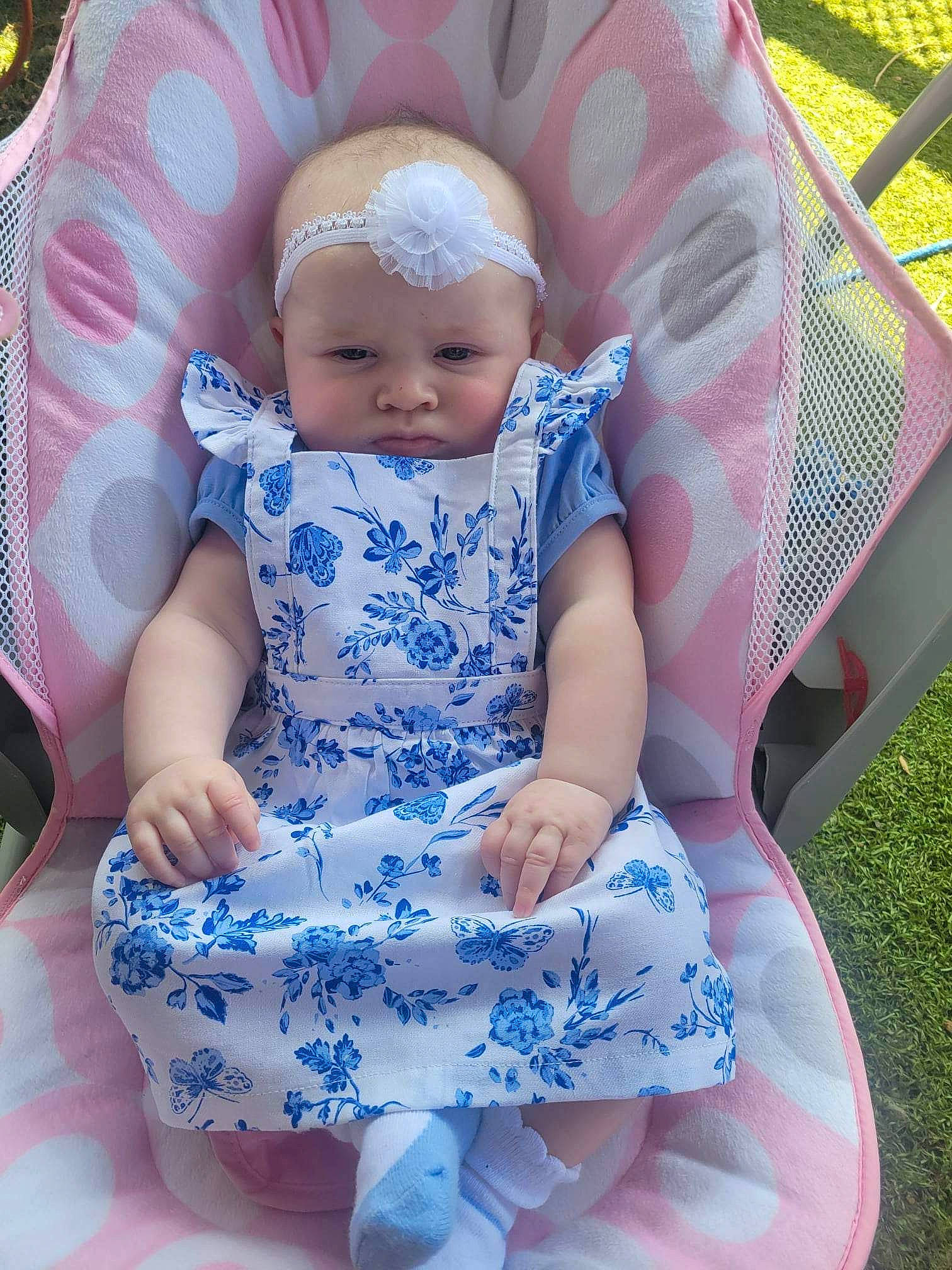 Mackenzie is registered to the contest to win money with this photo: baby, baby_toddler_clothing, chair, child, comfort, dress, electric_blue, grass, green, headwear, magenta, pattern, person, photograph, pink, product, purple, skin, sleeve, textile