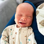 Vlad a rejoint le concours — aidez-le/la à gagner de superbes lots ! baby, newborn, infant, smiling, eyes_closed, onesie, zipper, blanket, swaddle, couch, bokeh, portrait, closeup, happy, relaxed, skin, head, cheeks, sleeping, home