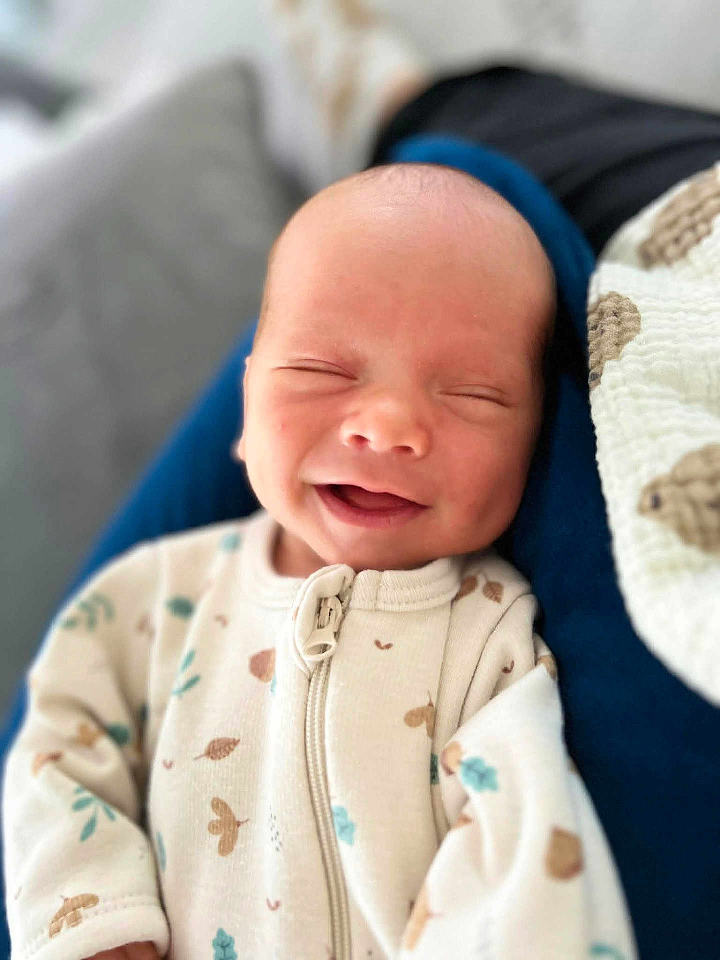 Vlad a rejoint le concours — aidez-le/la à gagner de superbes lots ! baby, newborn, infant, smiling, eyes_closed, onesie, zipper, blanket, swaddle, couch, bokeh, portrait, closeup, happy, relaxed, skin, head, cheeks, sleeping, home