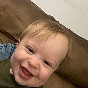 Kayce is registered to the contest to win money with this photo: baby, smiling, child, face, couch, indoor, happy, person, blond_hair, young, casual_clothing, closeup, portrait, infant, toddler, skin, cheerful, head, seated, relaxed