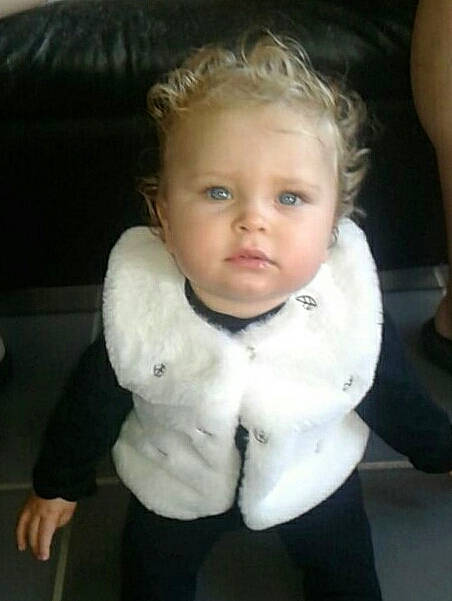 Khloé participe au concours pour gagner de l'argent avec cette photo : baby, blond, cheek, child, chin, ear, eye, face, forehead, hair, head, lip, neck, nose, outerwear, person, sitting, skin, smile, toddler