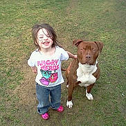 Buddy joined the competition — help win amazing prizes! child, dog, grass, outdoor, happy, smiling, casual_clothing, tshirt, jeans, pink_shoes, pet, animal, friendship, playful, nature, daylight, young, cute, fun, portrait