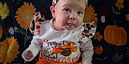 Izabella is registered to the contest to win money with this photo: autumn, baby, blanket, child, clothing, cute, face, fall, festive, headband, indoors, infant, orange, pattern, person, pumpkin, sitting, smile, sunflower, tongue_out