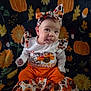 Izabella is registered to the contest to win money with this photo: baby, infant, child, cute, autumn, pumpkin, sunflower, blanket, headband, clothing, orange, pattern, sitting, tongue_out, smile, face, person, indoors, festive, fall