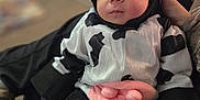 Izabella is registered to the contest to win money with this photo: animal_outfit, baby, black_and_white, blurred_background, child, clothing, costume, cow, cute, face, funny_costume, hand, indoors, infant, person, pink, portrait, sitting, soft_toys, warm