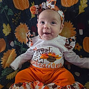 Izabella is registered to the contest to win money with this photo: baby, infant, smile, headband, autumn, pumpkin, blanket, fall, orange, clothing, child, cute, sitting, pattern, celebration, holiday, portrait, happy, person, indoors
