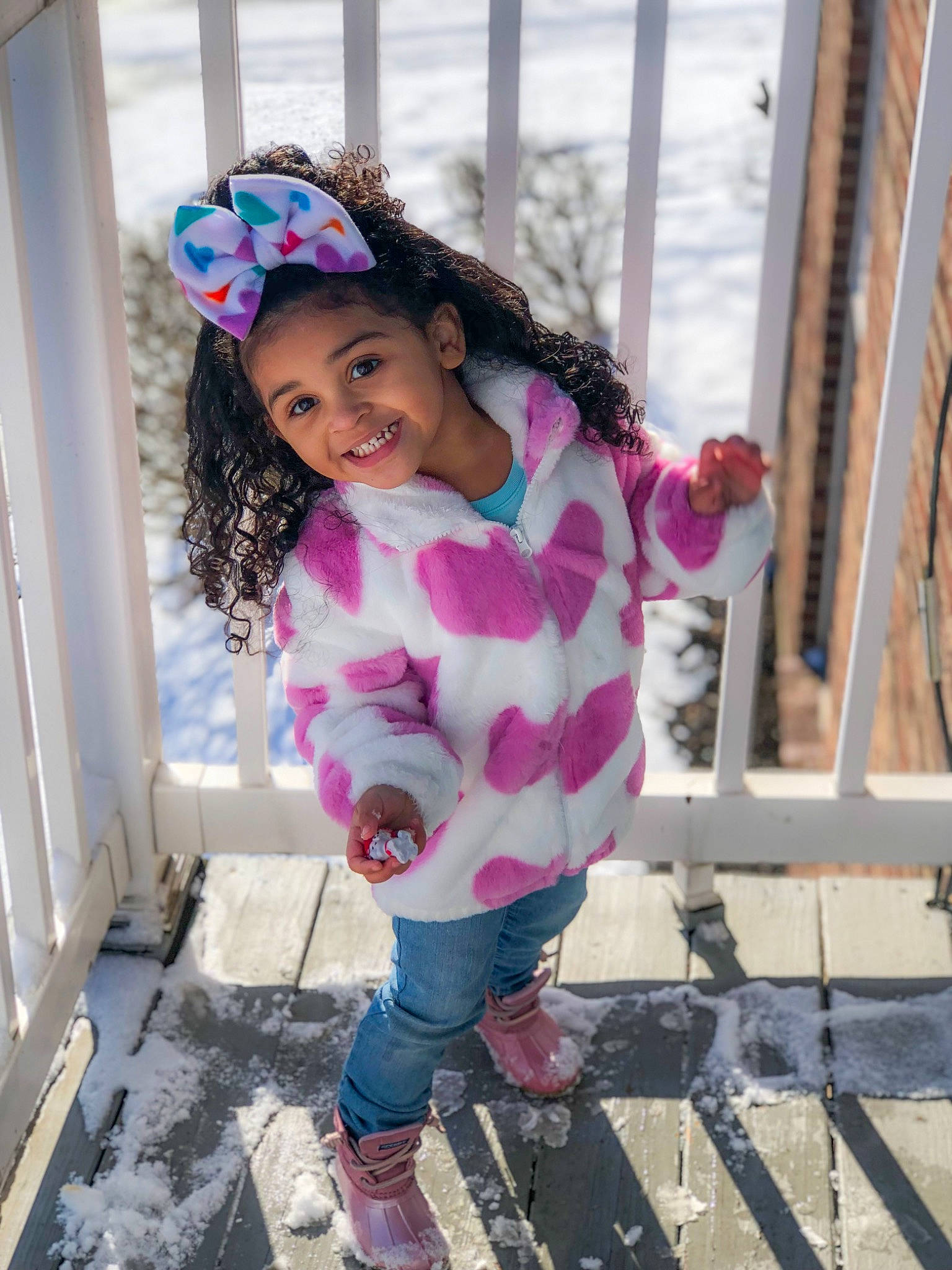 Naomi is registered to the contest to win money with this photo: baby_toddler_clothing, clothing, eye, face, fun, happy, headgear, joy, magenta, pattern, person, pink, purple, shoe, sleeve, smile, sneakers, snow, street_fashion, thigh