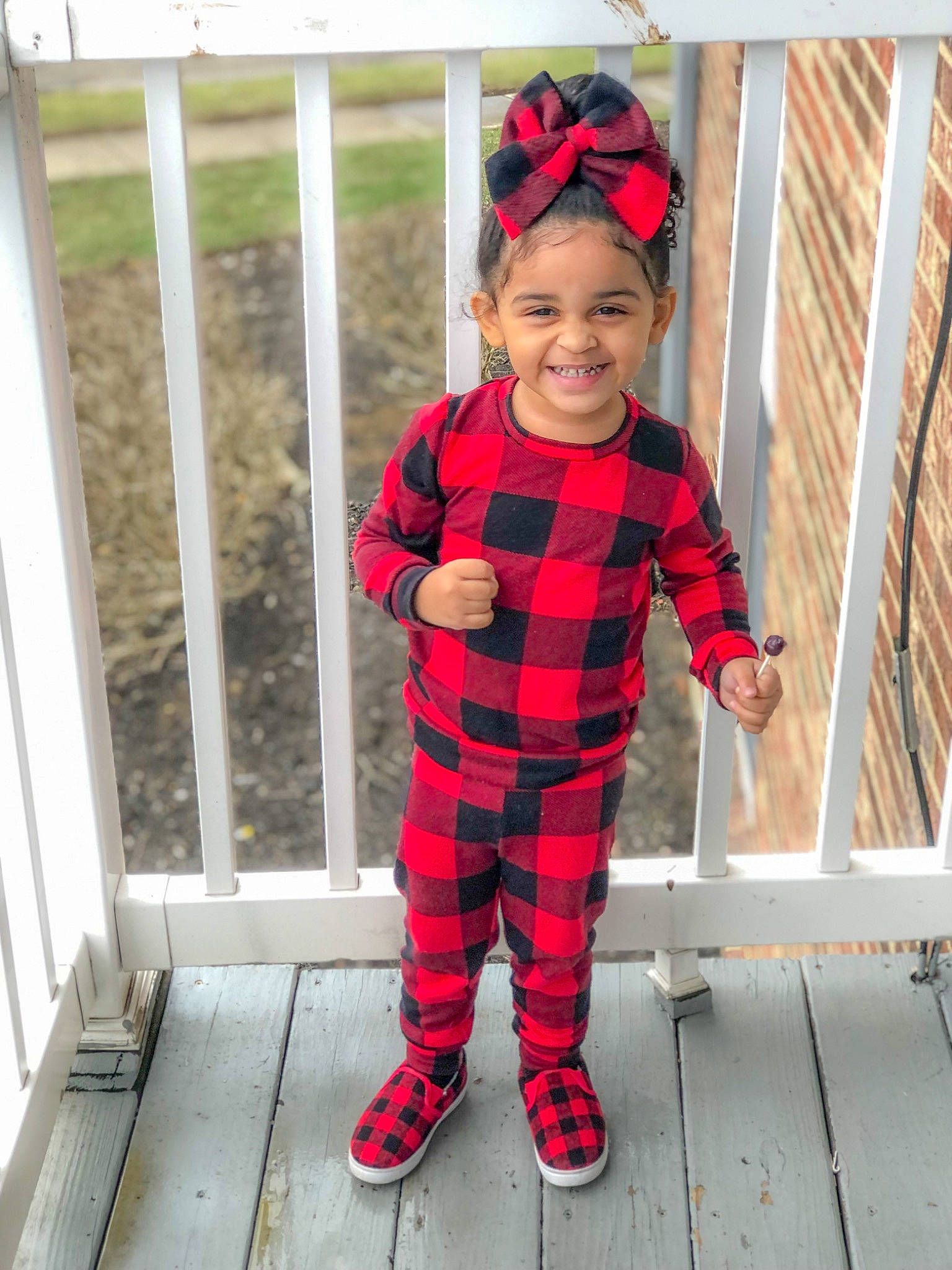 Naomi is registered to the contest to win money with this photo: clothing, fence, footwear, happy, headgear, headwear, human_body, jeans, joy, leg, outerwear, person, plaid, shoe, sleeve, smile, street_fashion, sunglasses, tartan, textile