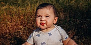 Ana is registered to the contest to win money with this photo: baby, butterfly_pattern, child, cute, daylight, expression, face, funny_face, grass, happy, nature, outdoor, person, portrait, shirt, sitting, skin, sunlight, toddler, young