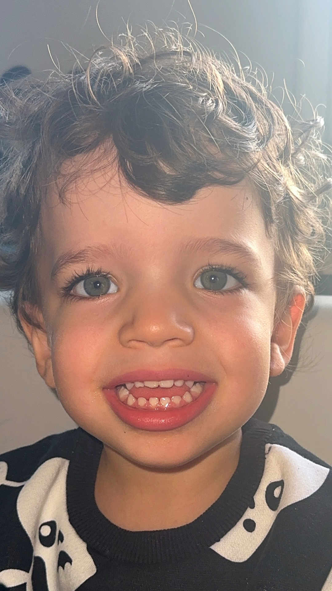 Santiago a rejoint le concours — aidez-le/la à gagner de superbes lots ! child, toddler, smiling, face, curly_hair, eyes, teeth, sweater, black_and_white, portrait, happy, closeup, person, indoor, cute, young, skin, mouth, expression, fashion