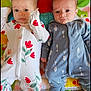 Kaiya And Delilah is registered to the contest to win money with this photo: baby, infant, twin, onesie, floral_pattern, arrow_pattern, play_mat, toy, carpet, cute, lying_down, indoor, child, face, expression, footwear, colorful, soft_light, closeup, person