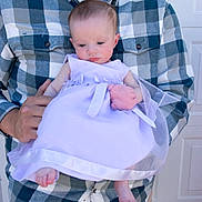 Kaiya And Delilah is registered to the contest to win money with this photo: baby, man, plaid_shirt, holding, dress, lavender, infant, portrait, outdoor, person, casual_clothing, cute, child, young, family, hands, feet, expression, gentle, background