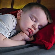 Chance joined the competition — help win amazing prizes! child, sleeping, pillow, bed, rest, peaceful, face, head, hand, young, indoors, cozy, red_pillow, gray_bedspread, relaxation, nap, portrait, tired, calm, soft_light