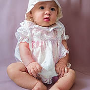 Shalynne is registered to the contest to win money with this photo: baby, infant, child, bonnet, dress, lacy_clothing, sitting, soft_background, curious_expression, barefoot, pink_tones, chubby_arms, chubby_legs, portrait, studio_photo, cute, innocence, closeup, indoor, person