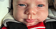 Thomas is registered to the contest to win money with this photo: baby, infant, face, blue_eyes, car_seat, seatbelt, clothing, red_stripes, close_up, child, person, cute, expression, indoor, pout, newborn, skin, head, sitting, comfort