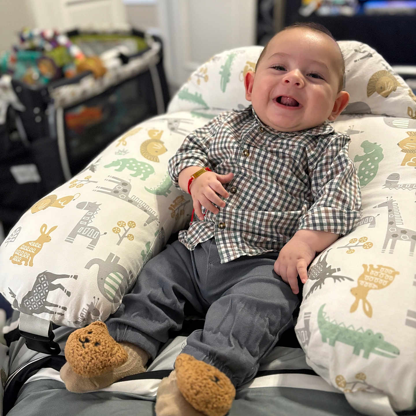 Mauricio José joined the competition — help win amazing prizes! baby, child, comfortable, cozy, cushion, cute, furniture, gray_pants, happy, home, indoor, infant, patterned_pillow, person, plaid_shirt, portrait, seated, smiling, teddy_bear_slippers, toy